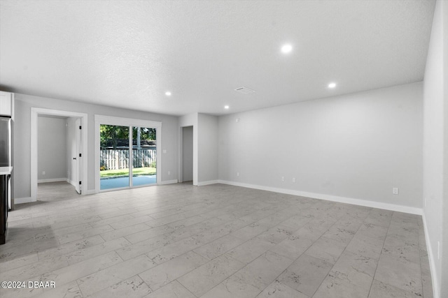 unfurnished room with a textured ceiling