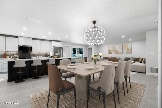 dining space featuring a chandelier and a textured ceiling