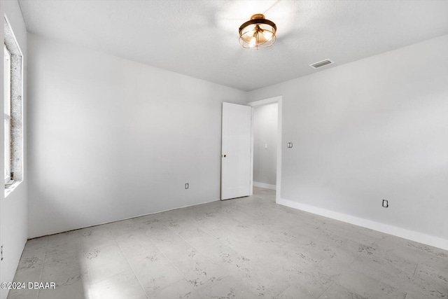 spare room with a textured ceiling