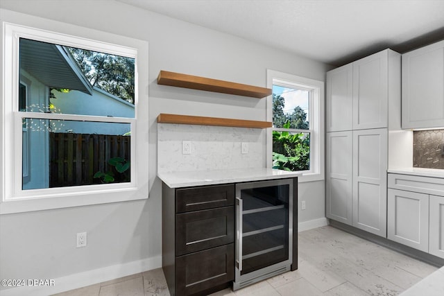 kitchen with white cabinetry, wine cooler, and backsplash