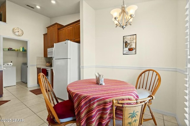 979 Leyburn Dr, Deltona, FL 32725 - dining area featuring recessed lighting, an inviting chandelier, washer and clothes dryer, light tile patterned flooring, and baseboards