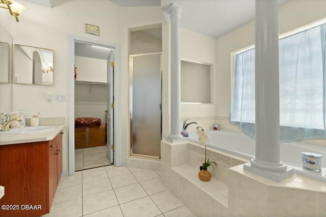979 Leyburn Dr, Deltona, FL 32725 - bathroom featuring a bath, tile patterned flooring, a shower stall, and ornate columns