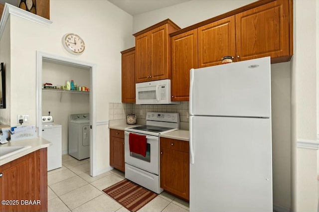 979 Leyburn Dr, Deltona, FL 32725 - kitchen featuring brown cabinets, decorative backsplash, light tile patterned floors, washing machine and dryer, and white appliances