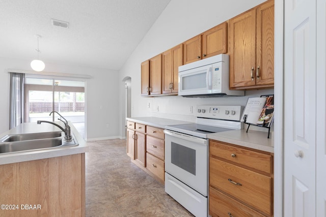 kitchen with white appliances, vaulted ceiling, light countertops, and a sink