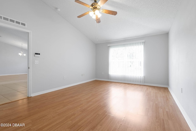 empty room featuring light wood-type flooring, a textured ceiling, and ceiling fan with notable chandelier