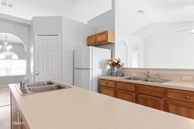 kitchen featuring light hardwood / wood-style floors, lofted ceiling, sink, and white fridge