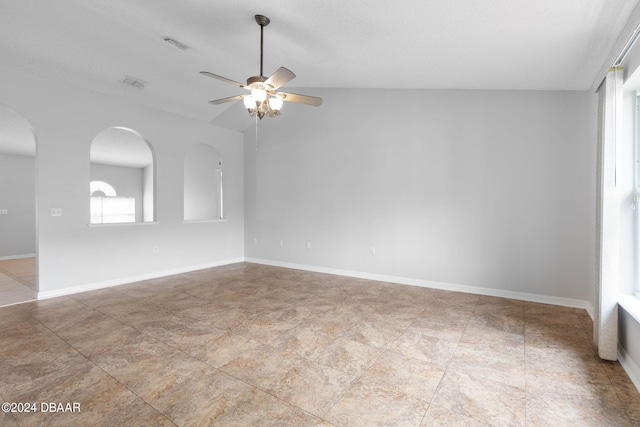 spare room featuring baseboards, visible vents, arched walkways, and ceiling fan