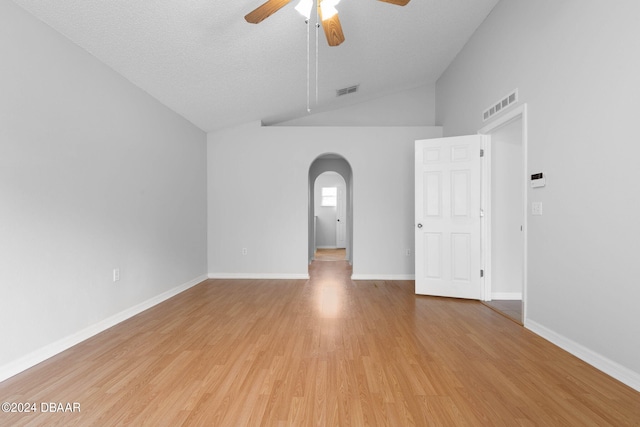 unfurnished room featuring light hardwood / wood-style floors, ceiling fan, a textured ceiling, and vaulted ceiling