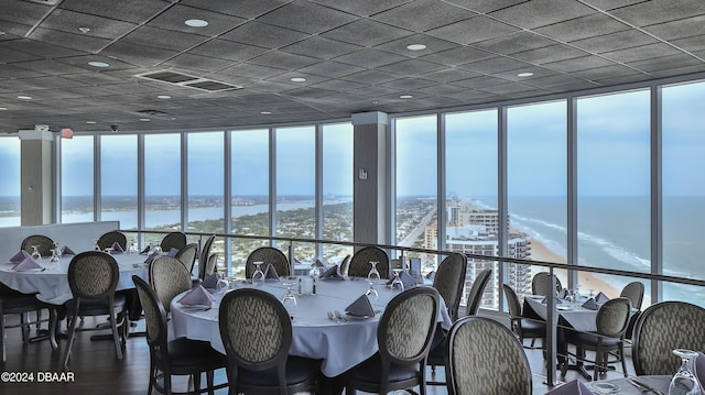 dining room with a wall of windows, a water view, and wood-type flooring