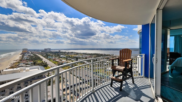 balcony featuring a water view and a beach view