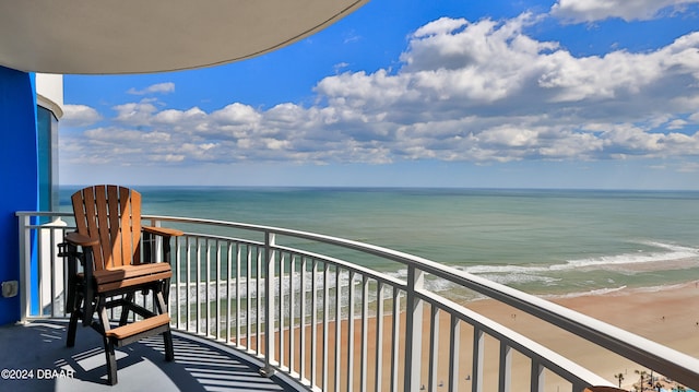 balcony featuring a view of the beach and a water view