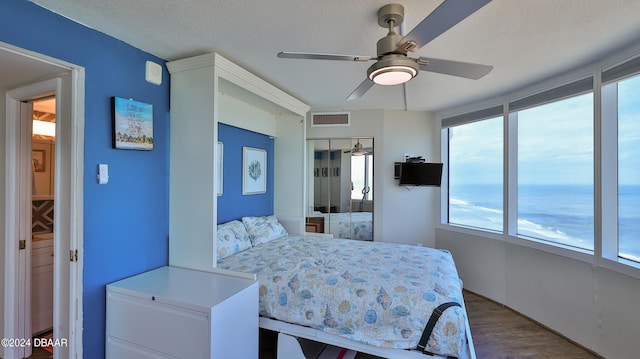 bedroom featuring a textured ceiling, hardwood / wood-style floors, ceiling fan, and a closet