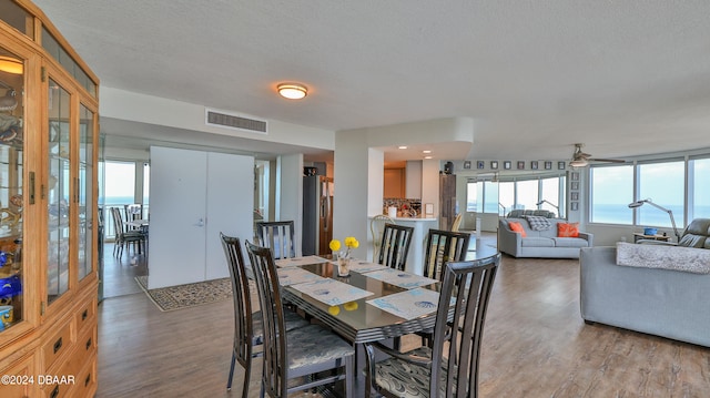 dining space featuring a textured ceiling, ceiling fan, and light hardwood / wood-style flooring