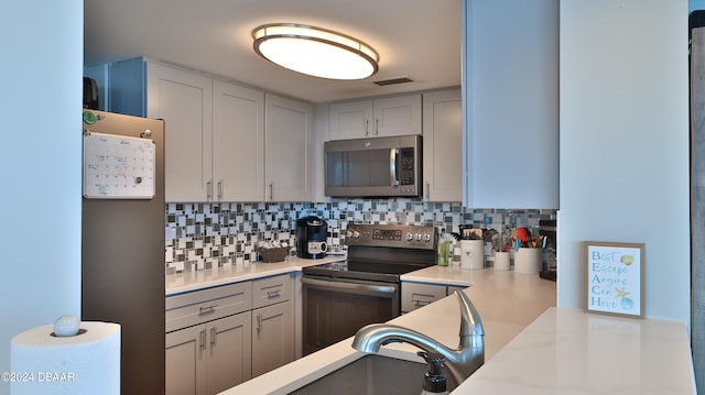 kitchen with tasteful backsplash, sink, and stainless steel appliances