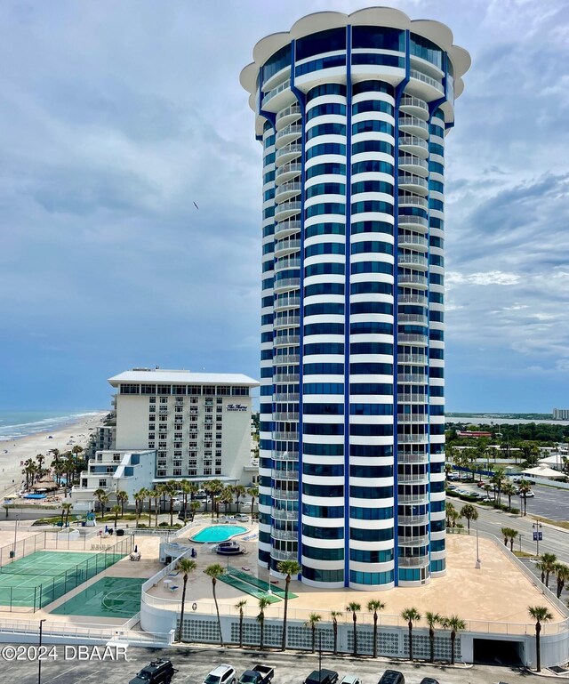 view of property with a beach view, a water view, and a community pool