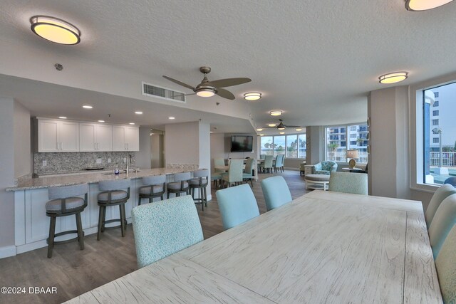 dining room featuring dark wood-type flooring, ceiling fan, a textured ceiling, and sink