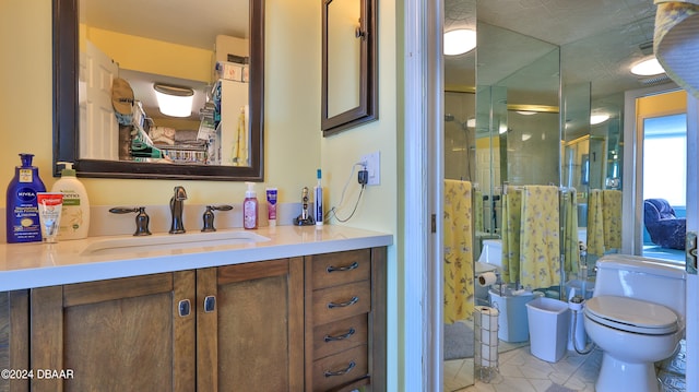 bathroom with toilet, vanity, and a shower with shower door