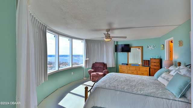 carpeted bedroom with multiple windows, a textured ceiling, and ceiling fan