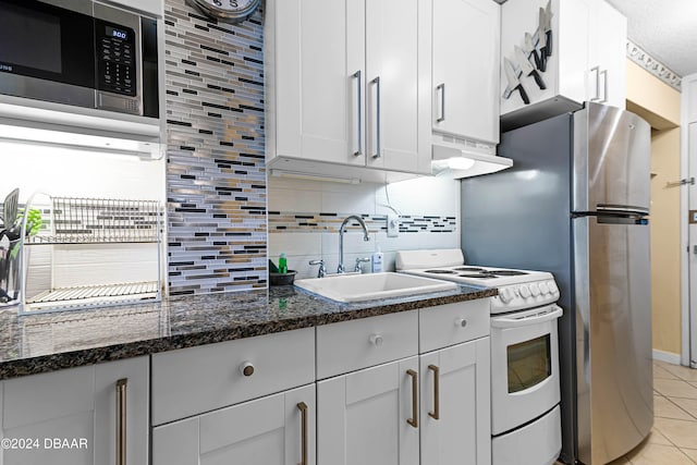 kitchen with range hood, sink, white cabinets, white stove, and stainless steel microwave