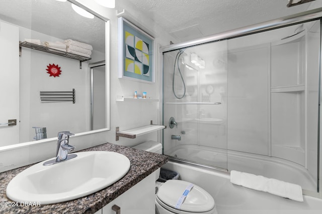 full bathroom with vanity, enclosed tub / shower combo, a textured ceiling, and toilet