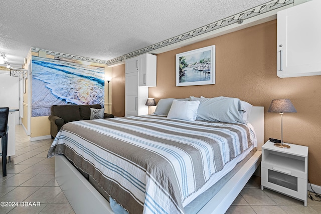 bedroom featuring a textured ceiling and light tile patterned floors