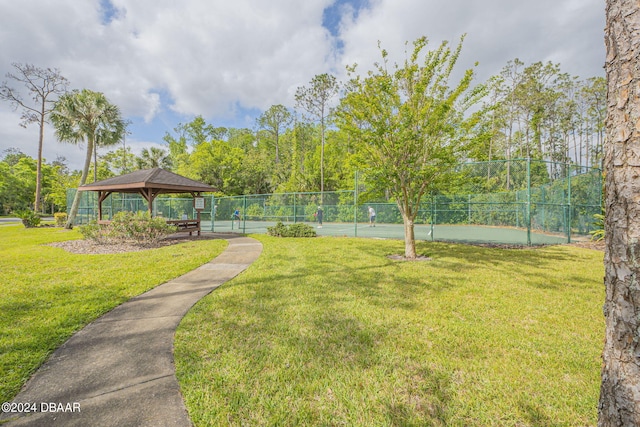 view of home's community with a lawn, tennis court, and a gazebo