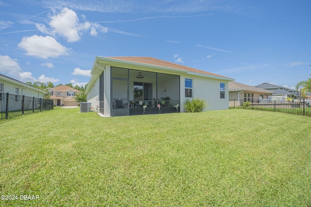 rear view of house featuring central air condition unit, a lawn, ceiling fan, and a sunroom