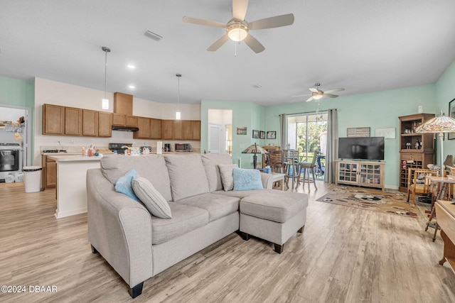 living room with light hardwood / wood-style floors and ceiling fan