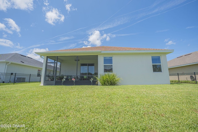 back of house with a sunroom, a lawn, and ceiling fan