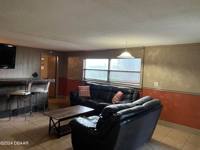 tiled living room with a textured ceiling and indoor bar