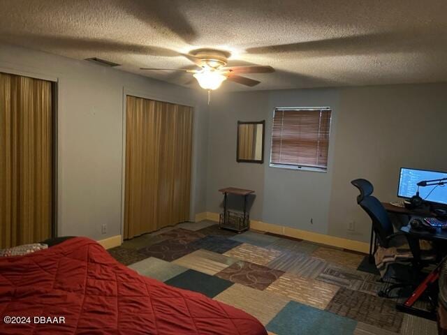 carpeted bedroom with a textured ceiling and ceiling fan