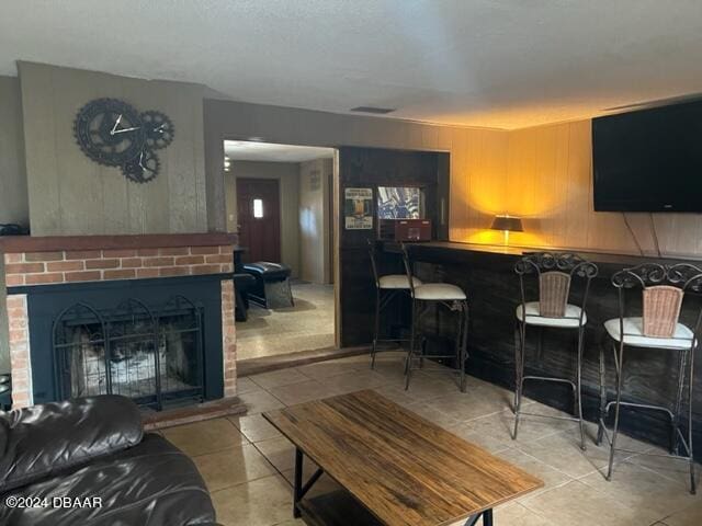 tiled living room with bar area and a fireplace