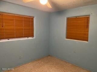 empty room with ceiling fan and carpet