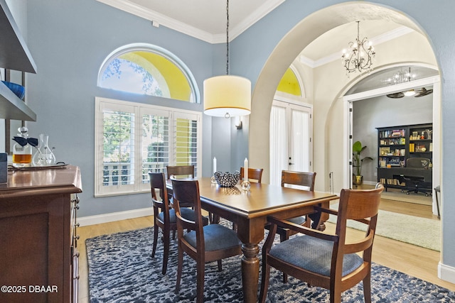 1207 Kaleen Dr, Ormond Beach, FL 32174 - dining area with a chandelier, arched walkways, light wood-type flooring, and crown molding
