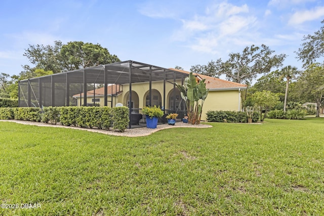1207 Kaleen Dr, Ormond Beach, FL 32174 - back of house featuring a tiled roof, a yard, stucco siding, and glass enclosure