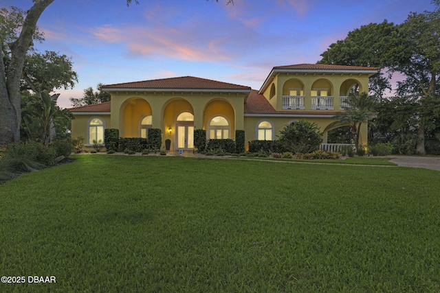 1207 Kaleen Dr, Ormond Beach, FL 32174 - mediterranean / spanish house featuring a tile roof, a front lawn, stucco siding, and a balcony
