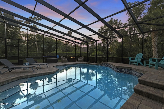 1207 Kaleen Dr, Ormond Beach, FL 32174 - pool at dusk featuring an outdoor pool, a patio area, and glass enclosure