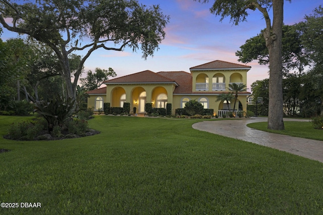 1207 Kaleen Dr, Ormond Beach, FL 32174 - mediterranean / spanish-style house featuring stucco siding, a front yard, a balcony, and curved driveway