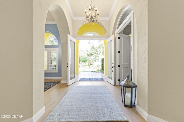 1207 Kaleen Dr, Ormond Beach, FL 32174 - foyer entrance with crown molding, a chandelier, a textured wall, and light wood-style flooring
