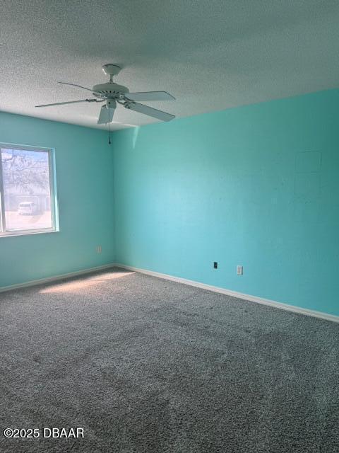 carpeted spare room with ceiling fan and a textured ceiling