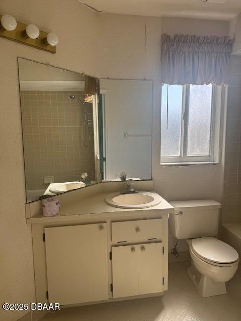 full bathroom featuring tiled shower / bath combo, vanity, and toilet