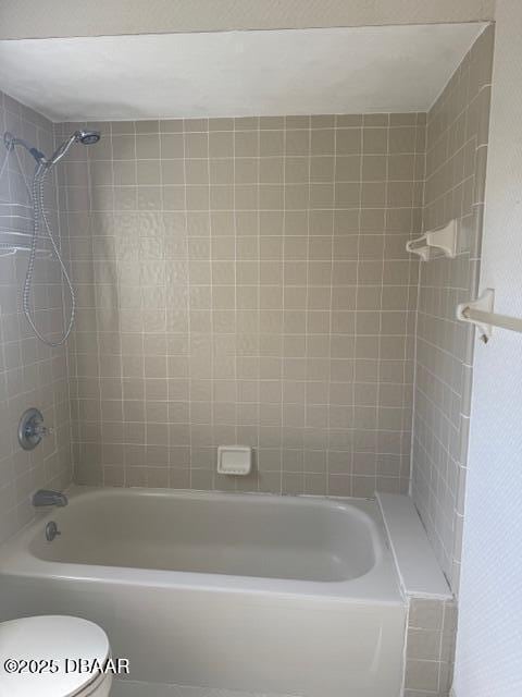 bathroom with tiled shower / bath and toilet