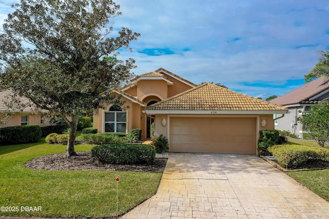 mediterranean / spanish home featuring a front yard and a garage