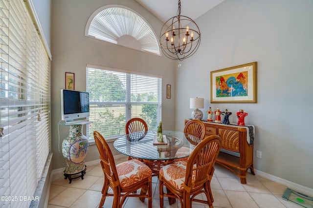 tiled dining room with a towering ceiling and an inviting chandelier