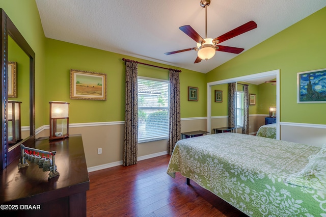 bedroom featuring ceiling fan, a textured ceiling, dark hardwood / wood-style floors, and lofted ceiling