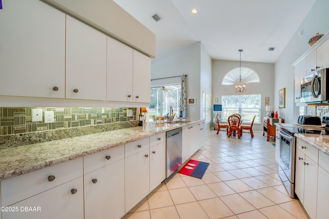 kitchen with white cabinetry, appliances with stainless steel finishes, pendant lighting, and backsplash