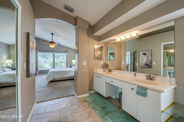 bathroom featuring ceiling fan, vanity, and vaulted ceiling