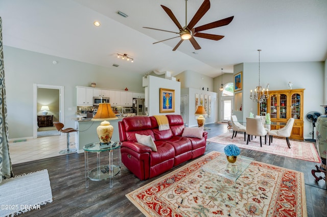 living room with ceiling fan with notable chandelier, dark hardwood / wood-style floors, and high vaulted ceiling