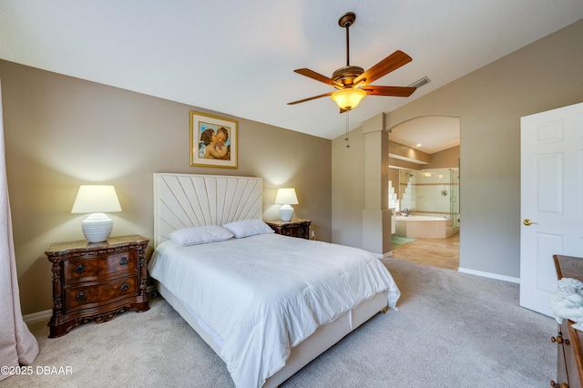 carpeted bedroom featuring ceiling fan, ensuite bathroom, and vaulted ceiling