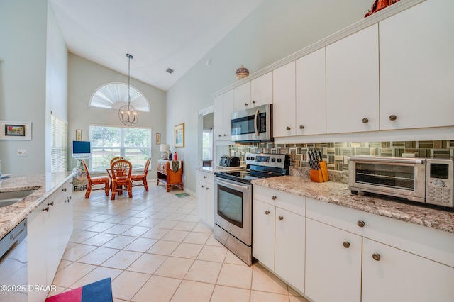 kitchen featuring tasteful backsplash, decorative light fixtures, a notable chandelier, stainless steel appliances, and white cabinets